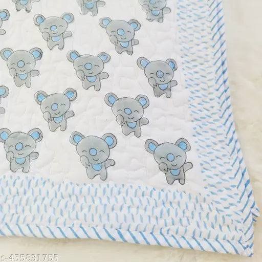 Cotton quilted baby bedding with blue print and light blue trim