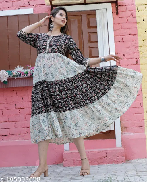 Woman in a patterned kameez with a flared hem, dancing against a pink wall