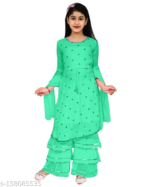 Green partywear dress with ruffled sleeves and a scoop neck, worn by a young girl in casual pose