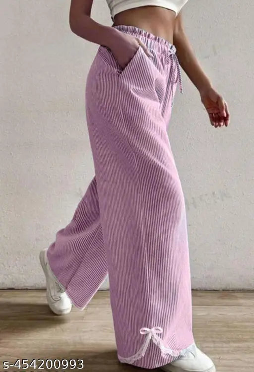 A person walking in a magenta striped pant with white sneakers