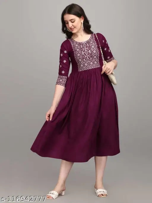 Maroon long flowy skirt, embroidered neckline, woman standing