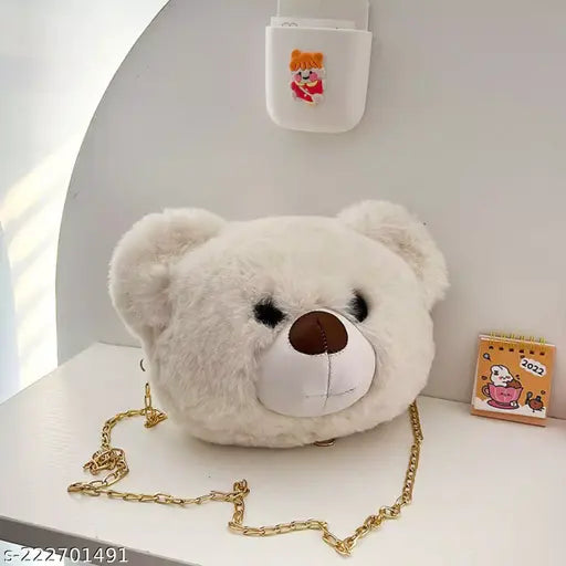 A golden chain mobile sling bag with a white stuffed animal resembling a teddy bear and a small card