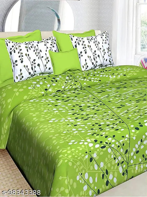 Green and white floral patterned bedding set with a mix of solid pillows