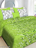 Green and white floral patterned bedding set with a mix of solid pillows