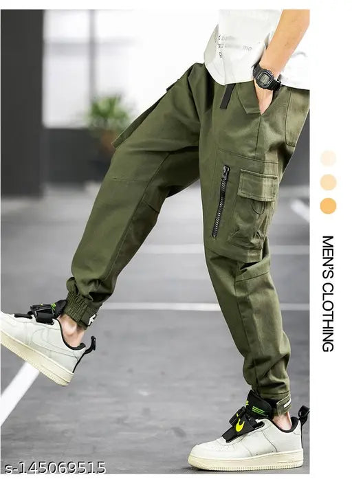 Green cotton cargo pants for men with drawstring waist and zip detail flap pockets, size M/L/XL/XXL. Relaxed fit, gusseted knees, elasticized leg openings. Product is made in India