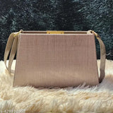 Beige canvas sling bag with gold hardware, adjustable strap