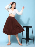 Woman in brown midi skirt, standing indoors against blue wall