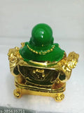 A small, green glass laughing Buddha figurine on a shelf