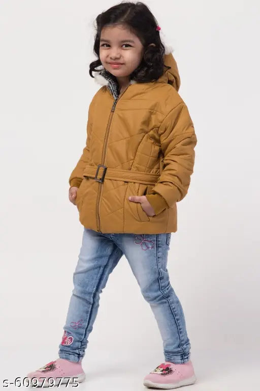 A young girl in a brown quilted jacket posing for the camera