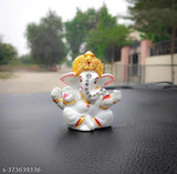 White ceramic Ganesha idol, golden color base, with blue fabric background