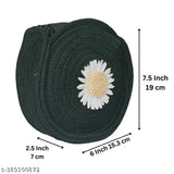 This is a black, jute and cotton sling bag with a flower adornment. It features a white flower embroidered on a black background and has a yellow center. The bag strap measures 75 cm in length