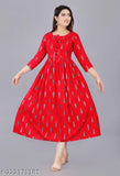A woman in a long, red anarkali kurta with a high neckline and short sleeves. She is standing with her arms by her sides