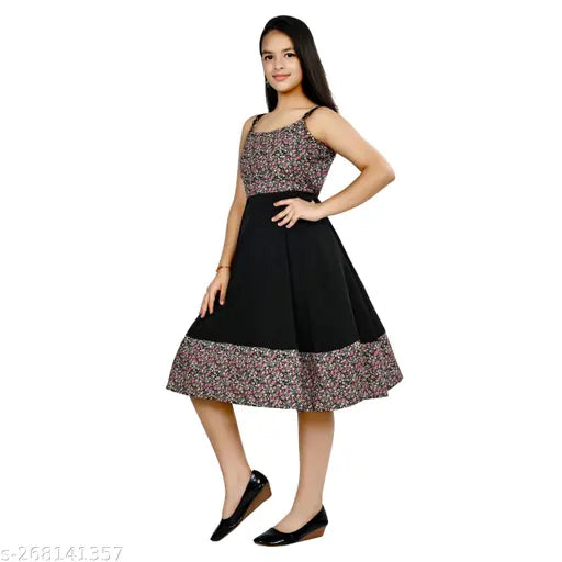 A young woman in a black, floral embroidered dress with short sleeves