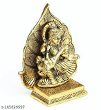 Golden antique metal statue of Maa Saraswati with a leaf backdrop