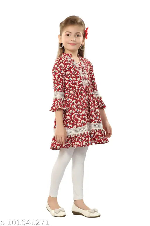 Printed polyester kurta set for kids, decorated with lace and pom-pom details, three-quarter sleeves, cotton lycra churidar bottoms. Available sizes: 5-6yrs, 6-7yrs, 7-8yrs, 8-9yrs, 9-10yrs, 10-11yrs, 11-12yrs, 12-13yrs, 13-14yrs. Indian handcrafted work on neckline. Origin: India