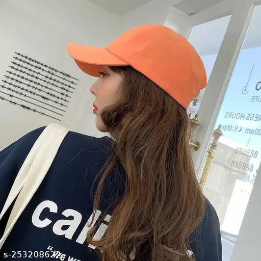 A person wearing an orange baseball cap with a trendy look, suitable for outdoor travels and sun protection