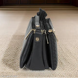 Black leather sling purse with adjustable strap and two front pockets, women's fashion accessory