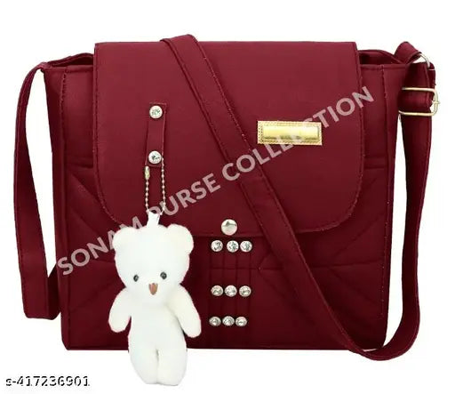 Red purse with metallic zippers and a teddy bear charm