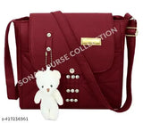Red purse with metallic zippers and a teddy bear charm