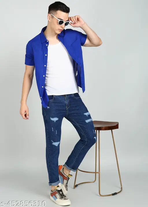 Dark blue denim jeans with distressed rips, cropped fit