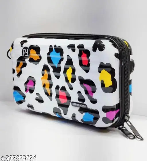 The image displays a small, compact suitcase with multiple compartments and a zipped main compartment. It features a vibrant pattern that includes shades of pink, blue, and yellow. The bag appears sturdy and suitable for travel, while its design also makes it fashionable and suitable as a handbag or shoulder bag