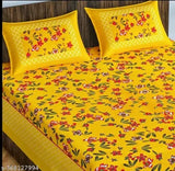 Yellow cotton Rajasthani bedsheet set with red floral print, 2 pillow covers.