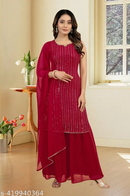 A woman wearing a vibrant red faux georgette kurta with embroidered sequins and matching sharara and dupatta