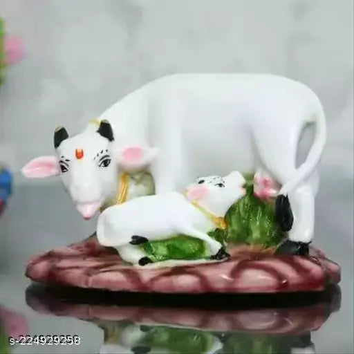 Colorful Kamdhenu statue decorative showpiece (Polyresin, White, Green) - Detailed cow and calf statue for interior decoration or tabletop display. Perfect for Pooja Mandir, spiritual showpieces in the North East direction per Vastu. Ideal gift for newborns, weddings, housewarming, and festive occasions. Handcrafted in India