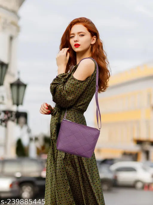 A woman stands on a street corner. She wears a purple dress with a lace pattern, holds a small blue purse, and has red hair. The background shows an urban setting with buildings and cars
