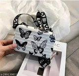Small, multi-colored suitcase-style sling bag, featuring a shoulder strap and butterfly pattern. Color shades may vary