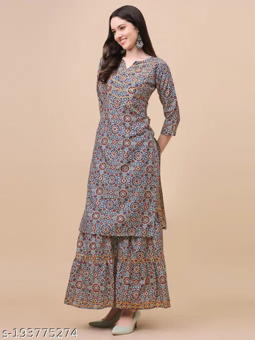 The image shows a woman in traditional South Asian attire, wearing a kurta sarara set. It is a long-sleeved outfit with flared bottoms and a fitted top. The kameez or kurta appears to be of solid color, and the pajama pants have a patterned design