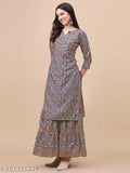The image shows a woman in traditional South Asian attire, wearing a kurta sarara set. It is a long-sleeved outfit with flared bottoms and a fitted top. The kameez or kurta appears to be of solid color, and the pajama pants have a patterned design