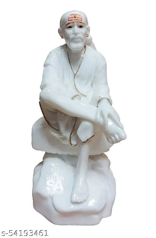 White marble statue of Sai Baba, seated in a traditional meditative posture, adorned with velvet dress and white embroidery