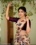 Woman in a printed sari, smiling and waving