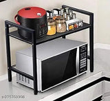 Black metal shelf with two shelves, holding microwave and oven, kitchen storage solution
