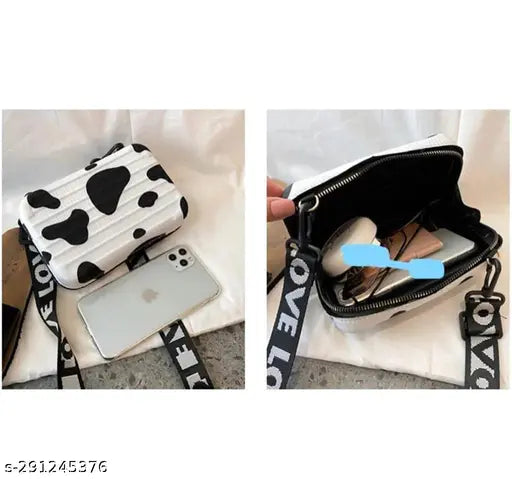 Mini suitcase style mackup purse, black and white cow print with shoulder strap, zip closure, multiple card slots, phone pocket