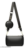 A fancy black leather sling bag with a small circular metal detail and adjustable strap