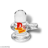 A clear glass shivalingam for pooja, with a red and gold label at the top