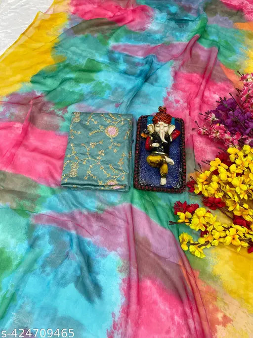 Vibrant printed sari with embroidery blouse piece, fabric draped on table, accompanied by floral garland and small box