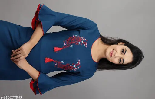 The image displays a woman wearing a dark blue kurta with embroidered details and a matching sharara. The kurta has short sleeves and features intricate floral designs on the bodice. It appears to be a part of a set that includes the kurta and shararas, as indicated by the title