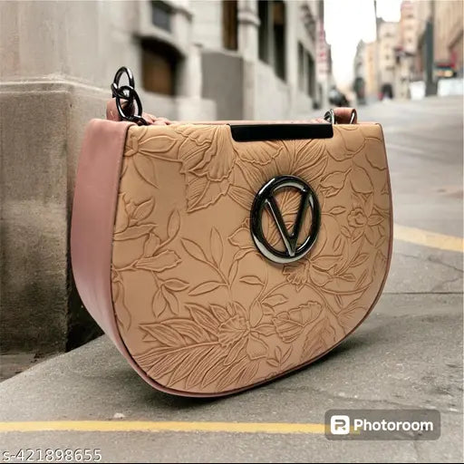 A large beige sling bag with a floral design, featuring a circular emblem and straps