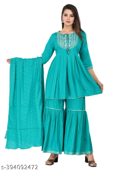 A woman wearing a long sleeve, knee length kurta with shararas and dupatta set in a vibrant sky blue color