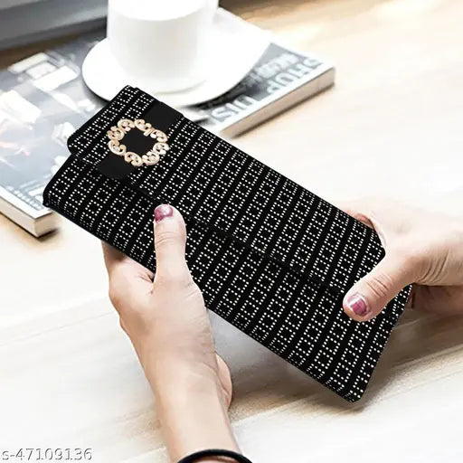 Black, glittering sling bag with a circular logo on a wooden table in a room