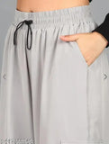 Oversized cargo pants with wide pockets for women, part of hippie streetwear trend, black color, material seems like cotton or polyester