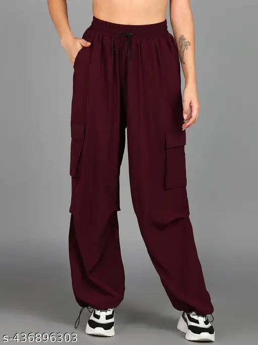 A person wearing high-waisted burgundy pants with cargo pockets, standing against a neutral background