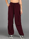 A person wearing high-waisted burgundy pants with cargo pockets, standing against a neutral background