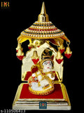 Gold-colored decorative umbrella with ornate designs, used as a car dashboard decoration for idols