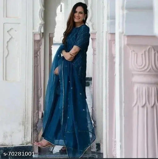 Blue embroidered sari with matching dupatta, worn by a woman standing in front of a white archway
