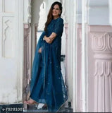 Blue embroidered sari with matching dupatta, worn by a woman standing in front of a white archway