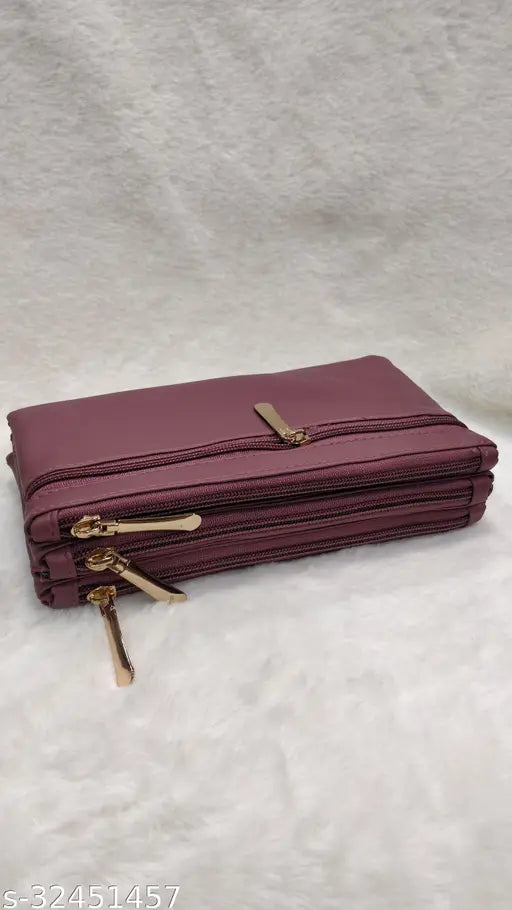 Elegant purple sling bag with gold zippers, multiple pockets and straps